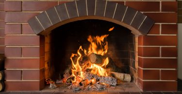 Uma lareira acesa dentro de uma casa. Lareiras.