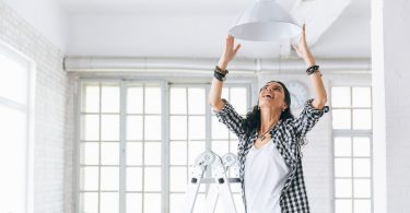 Uma mulher decorando a sala da sua casa. Apartamento casa alugada.