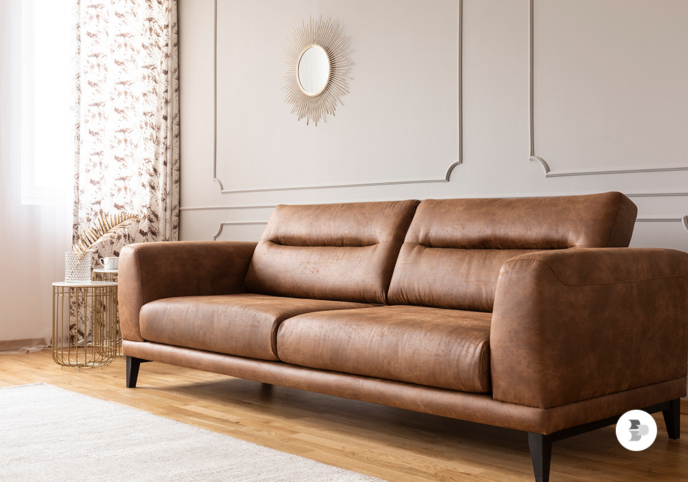 Uma sala com um sofá de couro, com estilo vintage. Escolher sofá.