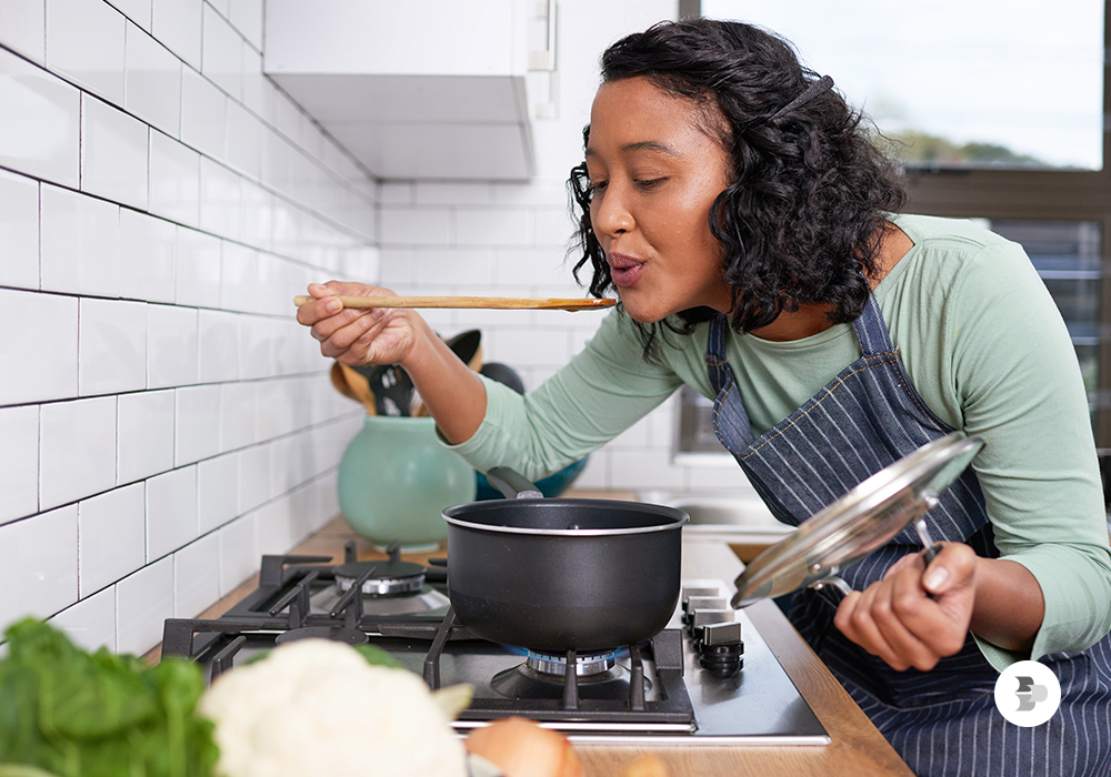 Uma moça cozinhando em seu fogão. GLP GN.