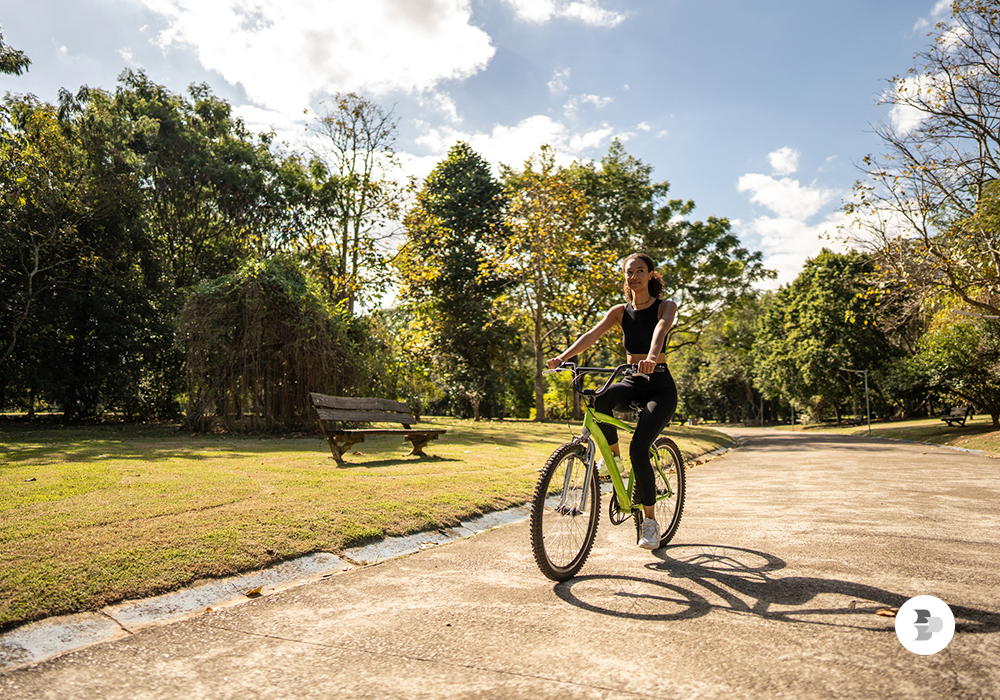 Uma moça andando de bicicleta em um parque. Andar bicicleta.