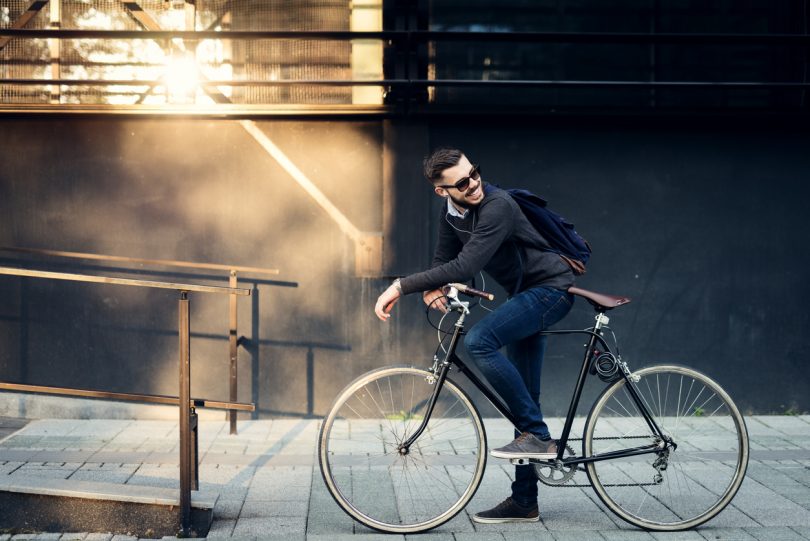 Um jovem pedalando em sua bicicleta. Bicicleta.