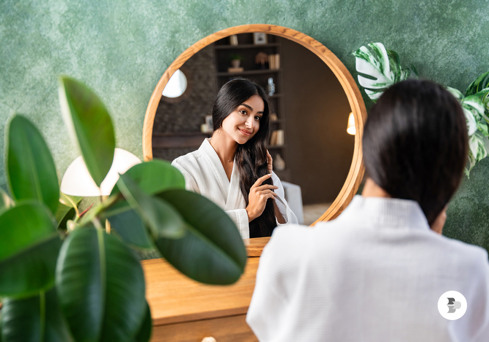 Uma moça cuidando dos seus cabelos enquanto se olha na penteadeira. Penteadeira.