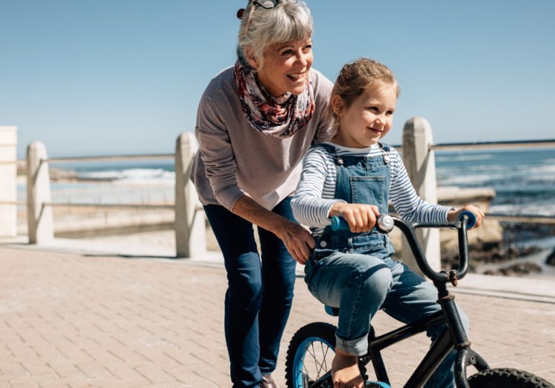 senior woman helping her granddaughter learn to ride a bicycle picture id1220309046