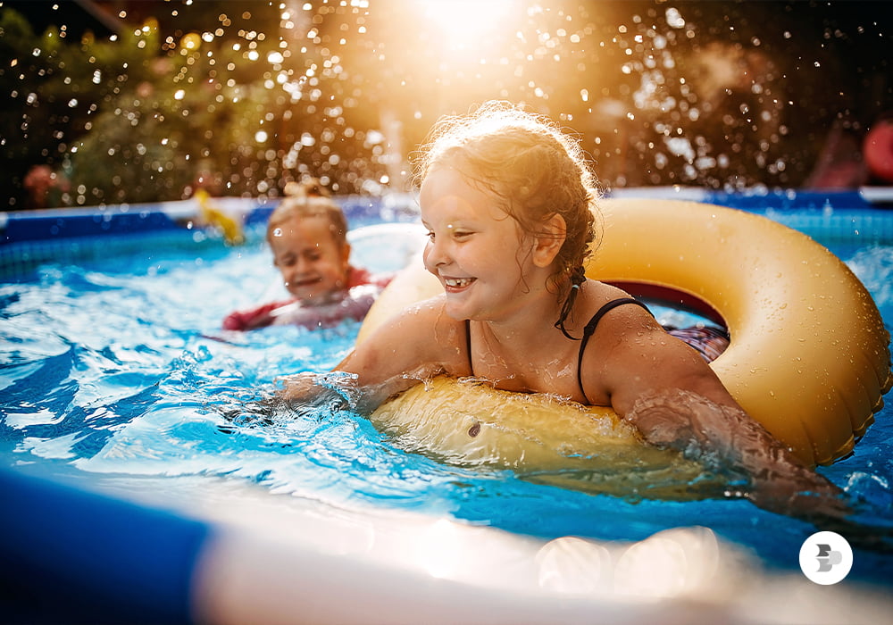 Duas crianças dentro de uma piscina brincando. Verão.