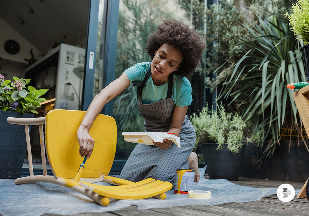 Mulher reformando a cadeira usada. Decoração Econômica.