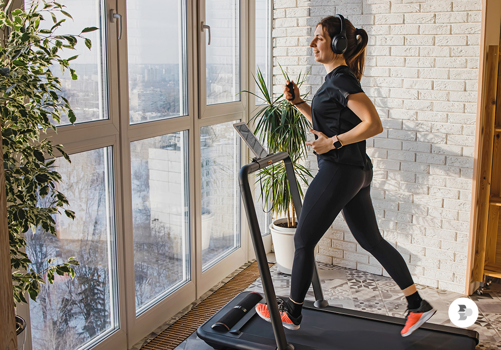 Mulher correndo na esteira ergométrica. Academia em casa.