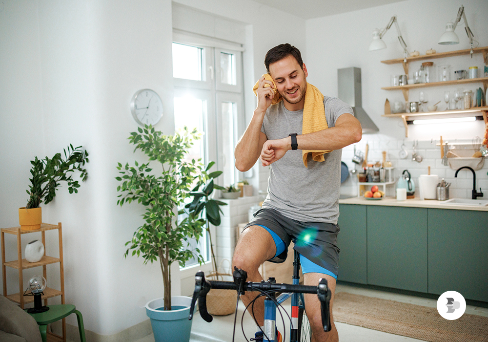 Homem pedalando na bicicleta ergométrica. Academia em casa.