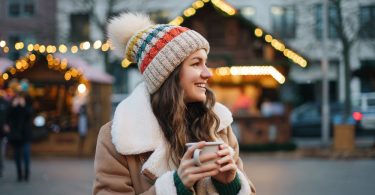 Uma moça com uma xícara de bebida quente aproveitando o inverno em um local turístico. Inverno brasileiro.