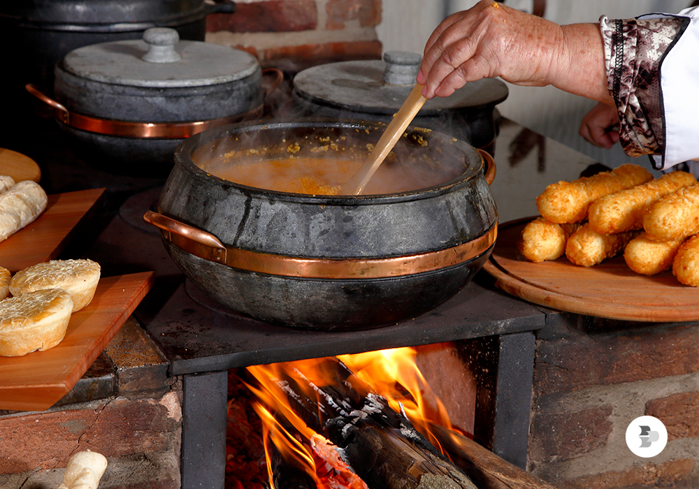 Um prato sendo preparado em um fogão a lenha. Fogão a lenha.