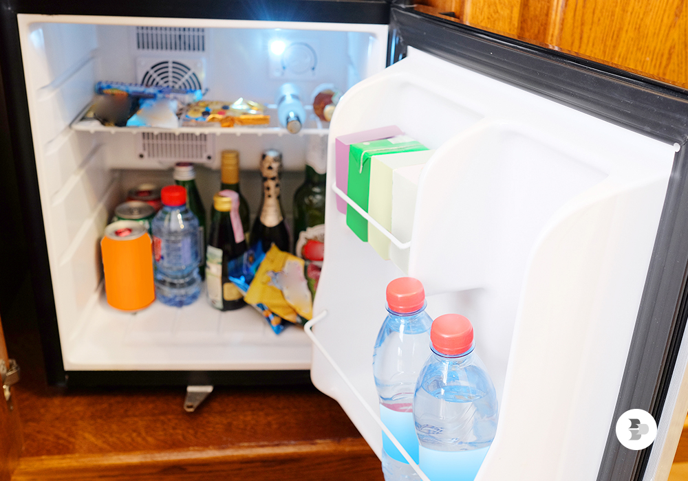 Vários tipos de alimentos dentro do frigobar. Frigobar.