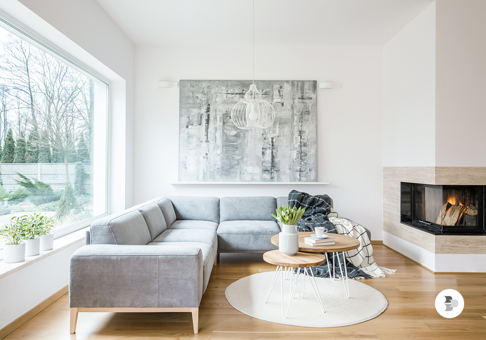 Um sofá de canto em uma sala de estar pequena, com manta decorativa e uma mesa de centro no meio da sala. Sofá ideal sala de estar.