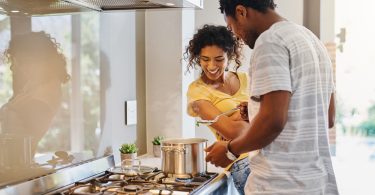 Marido e esposa cozinhando juntos em um fogão. Fogão de cozinha.