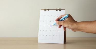 Uma pessoa marcando no calendário um dia específico. Calendário.