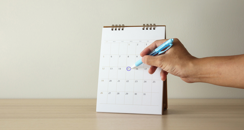 Uma pessoa marcando no calendário um dia específico. Calendário.
