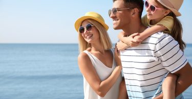 Uma família aproveitando o dia na praia. Curtir verão.