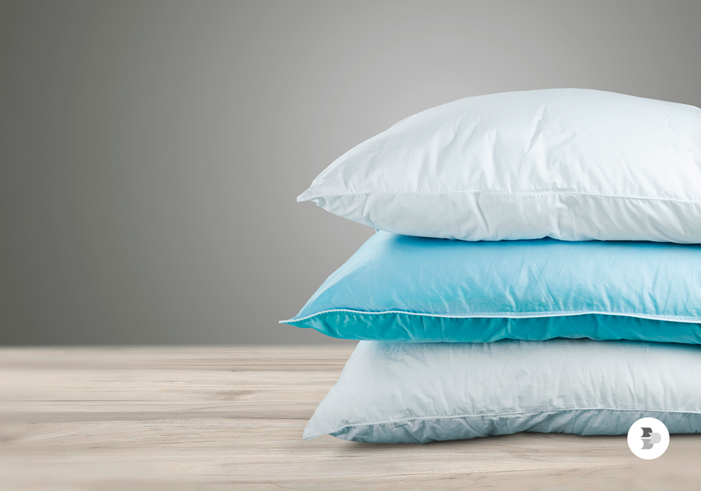 Alguns travesseiros empilhados em cima de uma superfície. Travesseiro.