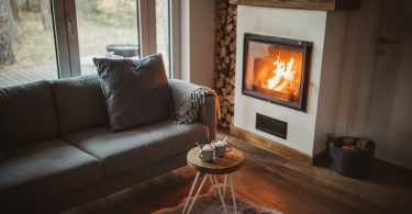 Uma Sala de Estar com lareira e sofá aconchegante. Casa aquecida.