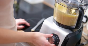 Uma pessoa utilizando o multiprocessador na sua cozinha. Multiprocessador.