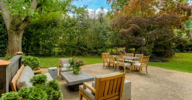 Um jardim com vários móveis em sua decoração. Móveis para jardim.