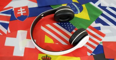 Um fone de ouvido com várias bandeiras de países ao redor. Novo idioma.