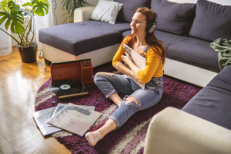 Uma jovem ouvindo seus discos de vinil em casa. Discos de vinil.