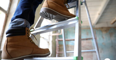 Uma pessoa em cima de uma escada. Escada.