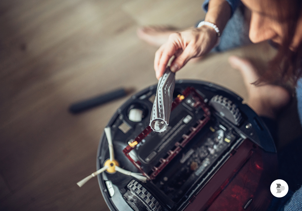 Pessoa fazendo a limpeza do aspirador de pó robô. Aspirador robô.