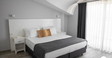 Um quarto organizado com uma cama e sua base. Base para cama.