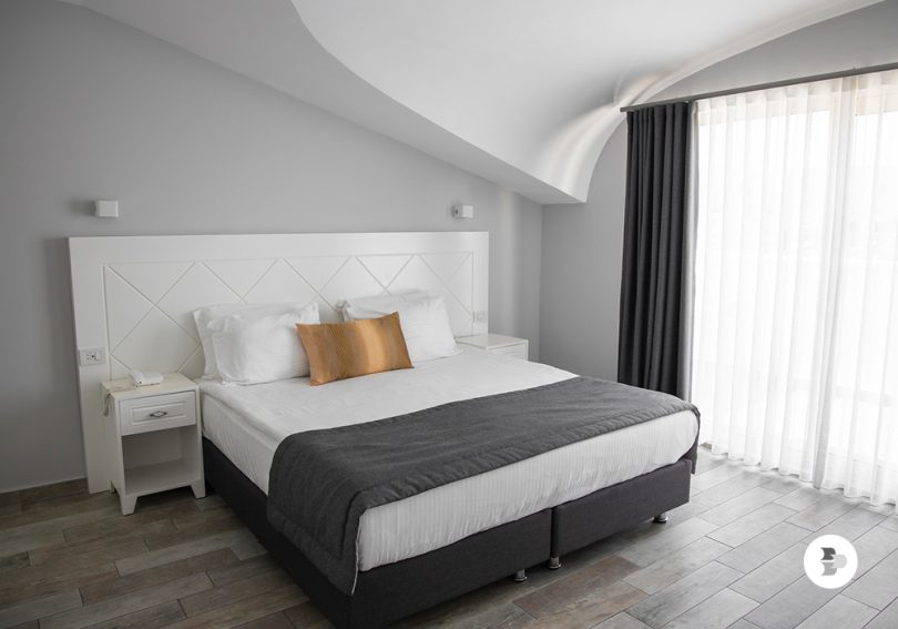 Um quarto organizado com uma cama e sua base. Base para cama.