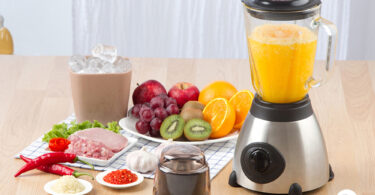Uma mesa com ingredientes e um liquidificador com suco. Liquidificador ideal.