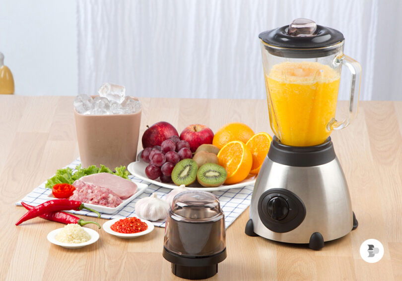 Uma mesa com ingredientes e um liquidificador com suco. Liquidificador ideal.