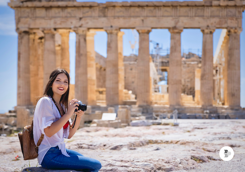 Uma moça tirando fotos do Partenon, em Atenas. Dicas viagem.