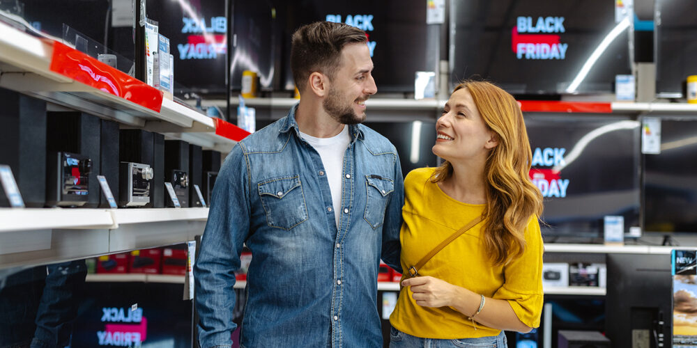 Um casal em uma loja comprando produtos durante a Black Friday. Comprar Black Friday.