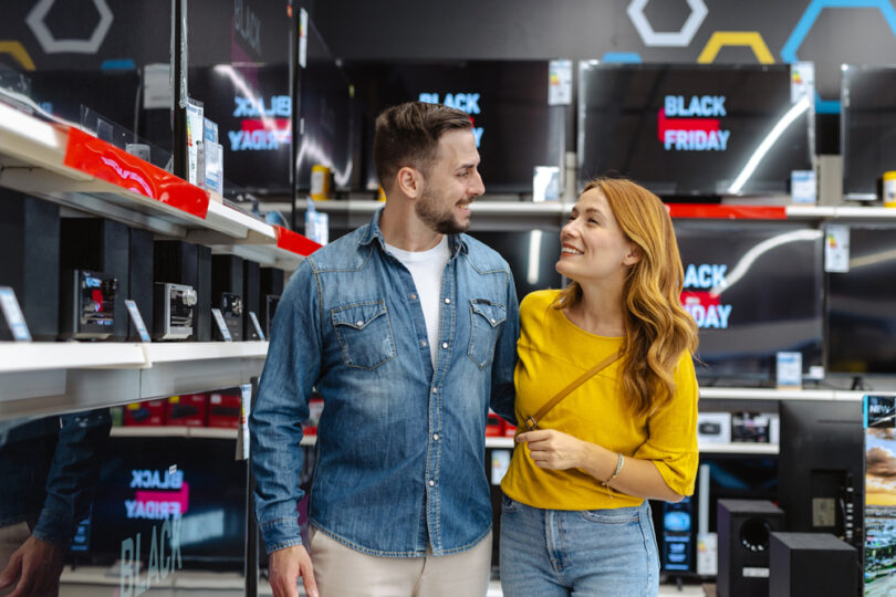 Um casal em uma loja comprando produtos durante a Black Friday. Comprar Black Friday.