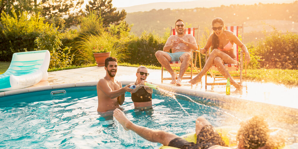 Um grupo de amigos se divertindo dentro de uma piscina. Piscina grande.