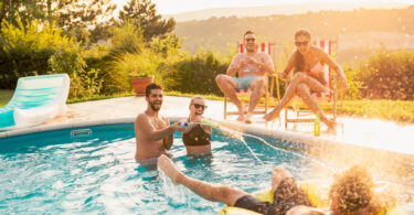 Um grupo de amigos se divertindo dentro de uma piscina. Piscina grande.