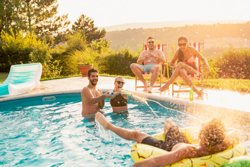 Um grupo de amigos se divertindo dentro de uma piscina. Piscina grande.