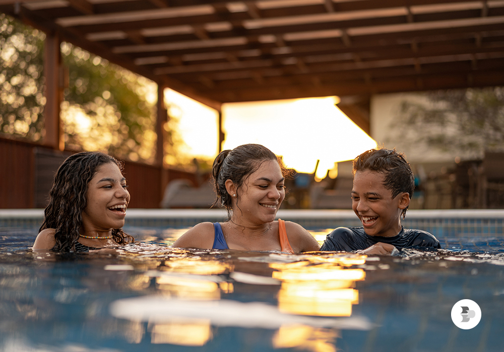Mãe e filhos se divertindo dentro da piscina. Combo perfeito verão.