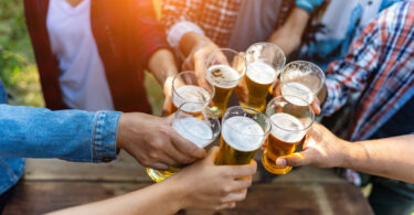 Amigos brindando cerveja enquanto fazem festa no fim de ano. Cervejeira Consul.