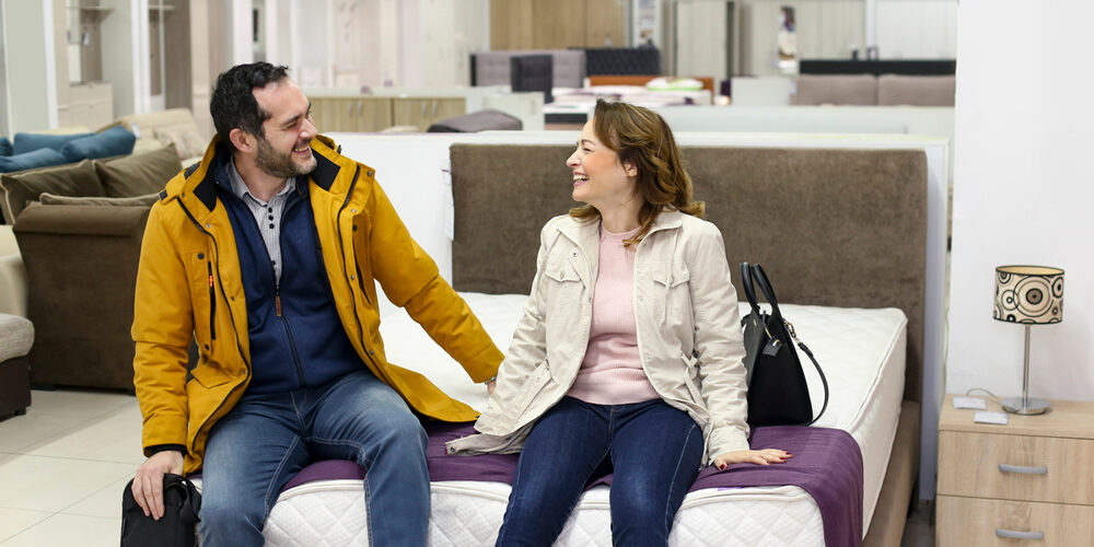 Um casal comprando o seu colchão em uma loja de colchões. Colchões.