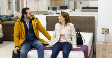 Um casal comprando o seu colchão em uma loja de colchões. Colchões.