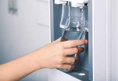 Uma pessoa pegando água para beber. Benefícios purificador de água.