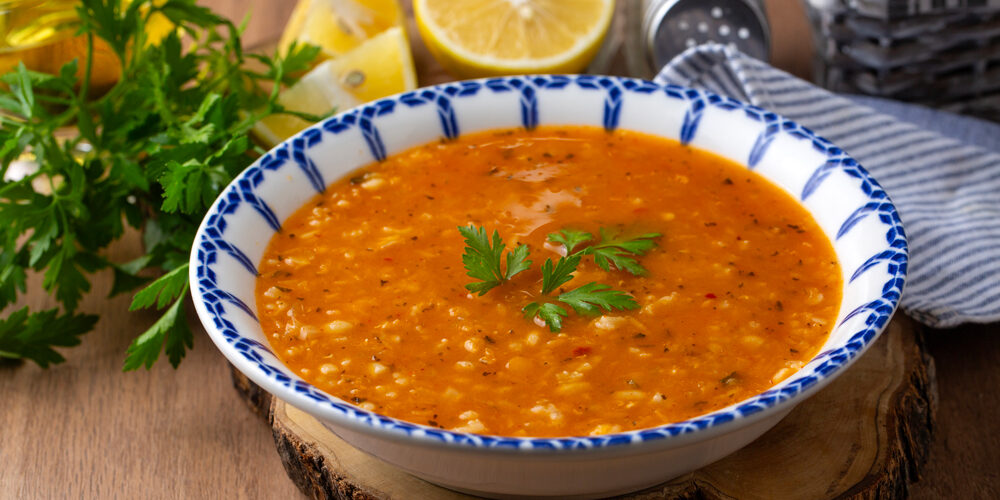 Uma sopa em cima de uma mesa, com tempero por cima. Receitas sopa.