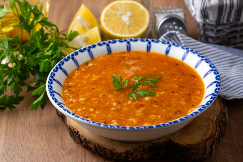 Uma sopa em cima de uma mesa, com tempero por cima. Receitas sopa.
