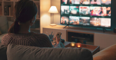 Um moça explorando todos os recursos da sua Smart TV. TV 3.0.