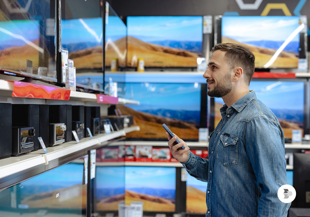Um jovem comprando a sua Smart TV em uma loja. TV 3.0.